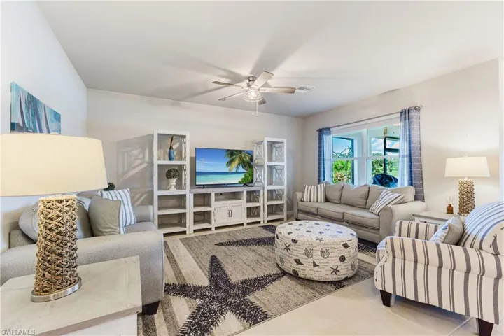 Recessed lighting, ceiling fan, tile flooring, window with exterior exposure, and media console with integrated shelving