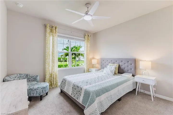 Carpeted flooring, window with natural light, and a ceiling fan with integrated lighting