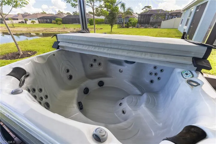 Outdoor hot tub with integrated controls, multiple jets, and a fitted cover