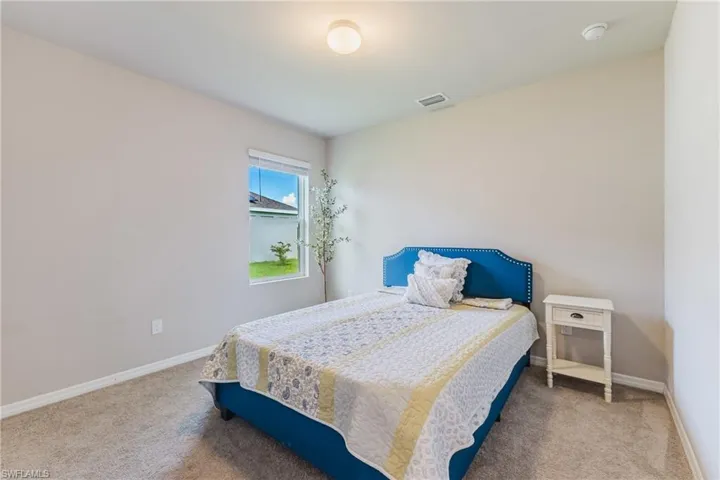 Light gray wall paint, carpeting, and a single window with white trim
