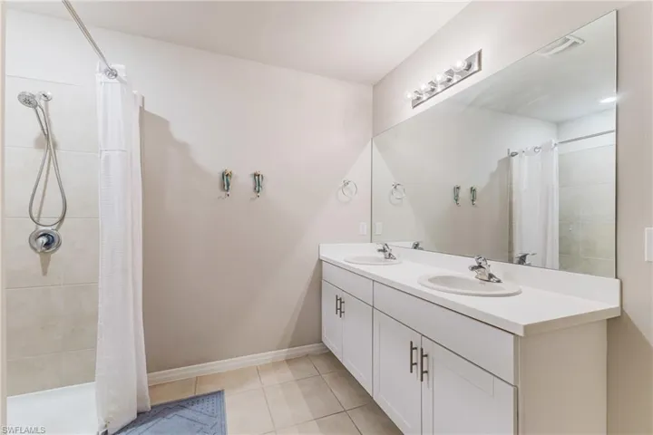 Dual vanity with integrated sinks, expansive mirror, and brushed nickel light fixture