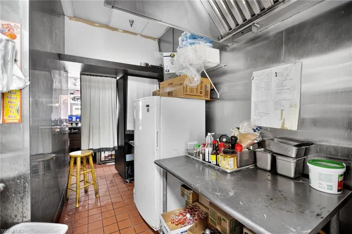 Kitchen featuring freestanding refrigerator and dark tile patterned flooring