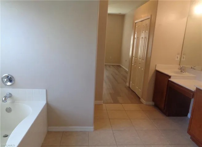 View of the Master Bedroom's bathroom with Tub, double sink vanity and tile flooring