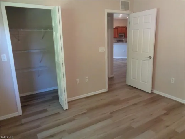Guest Bedroom 1 with closet and wood-like flooring