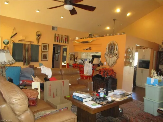 Living room featuring a ceiling fan, lofted ceiling, recessed lighting, and wood finished floors