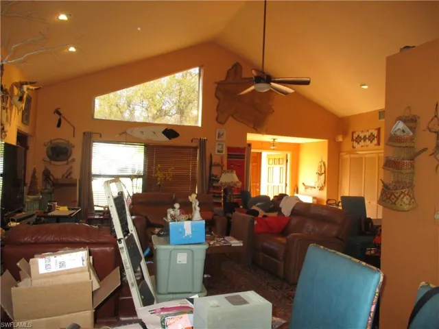 Living room featuring recessed lighting, a ceiling fan, and a high ceiling