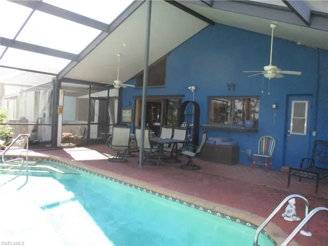 View of swimming pool with a pool, glass enclosure, and patio surround