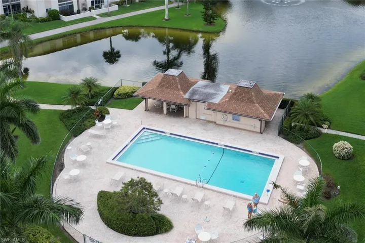 Community pool with a patio, a water view, and a yard