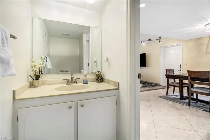 Bathroom featuring light marble finish floors and vanity
