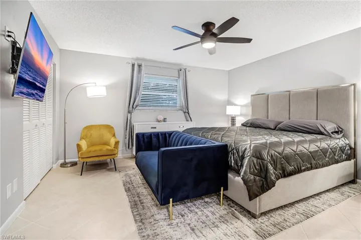 Tiled bedroom featuring a textured ceiling and a ceiling fan