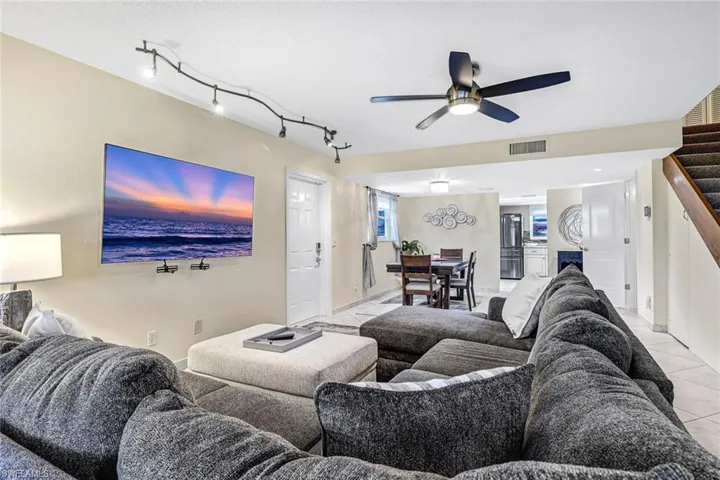 Living room featuring a ceiling fan and rail lighting