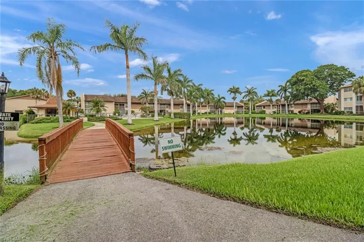 Dock featuring a water view, a lawn, and a residential view