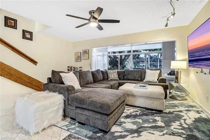 Living area with a ceiling fan and baseboards