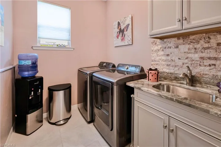 convenient inside laundry complete with sink, granite counter and cabinets
