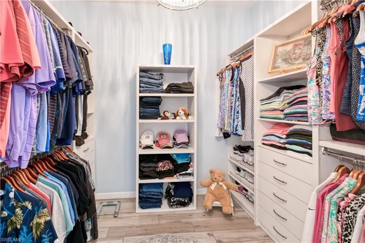 huge primary walk-in closet with custom shelving