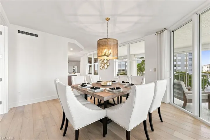 Light wood-finish flooring, a contemporary chandelier, and full-height glass sliding doors