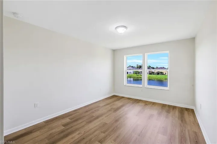 Empty room with a water view and hardwood / wood-style floors