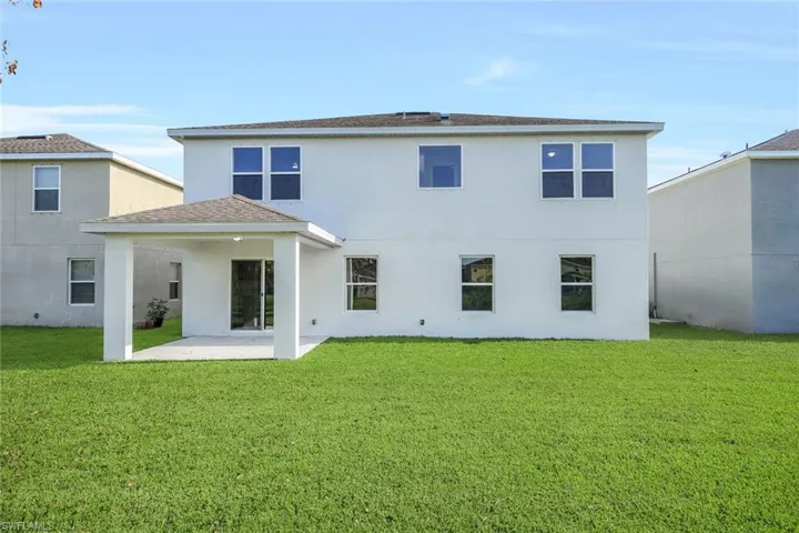 Rear view of property with a patio and a yard