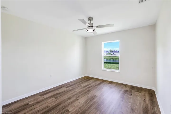 Unfurnished room featuring dark hardwood / wood-style flooring and ceiling fan