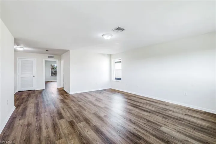 Unfurnished living room featuring dark hardwood / wood-style floors
