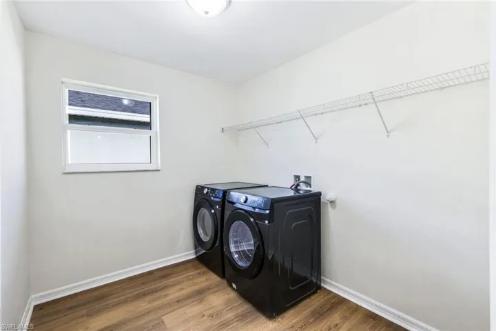 Laundry room featuring washer and dryer and wood-type flooring