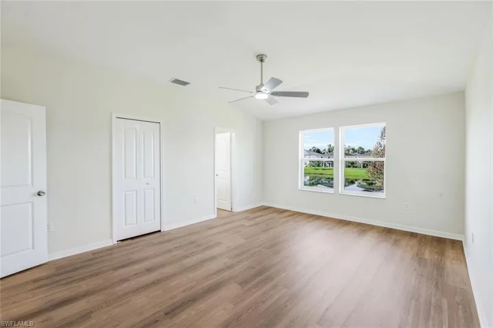Unfurnished bedroom featuring lofted ceiling, ceiling fan, and wood-type flooring