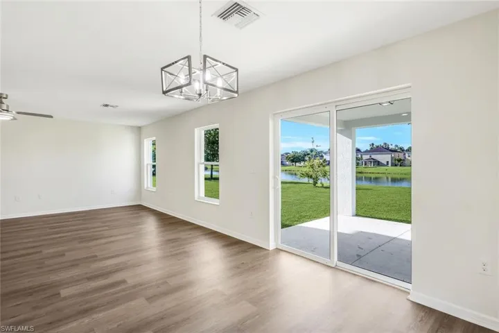 Entryway featuring a water view, hardwood / wood-style flooring, and ceiling fan with notable chandelier