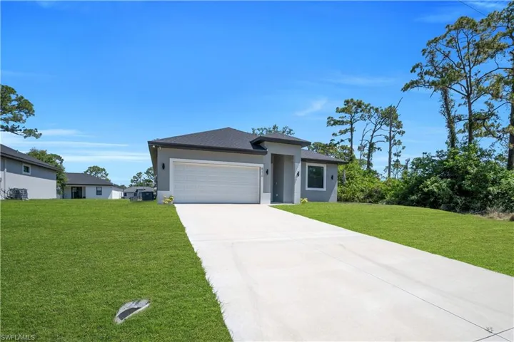 Contemporary stucco exterior featuring a two-car garage, a dark shingle roof, and a concrete driveway