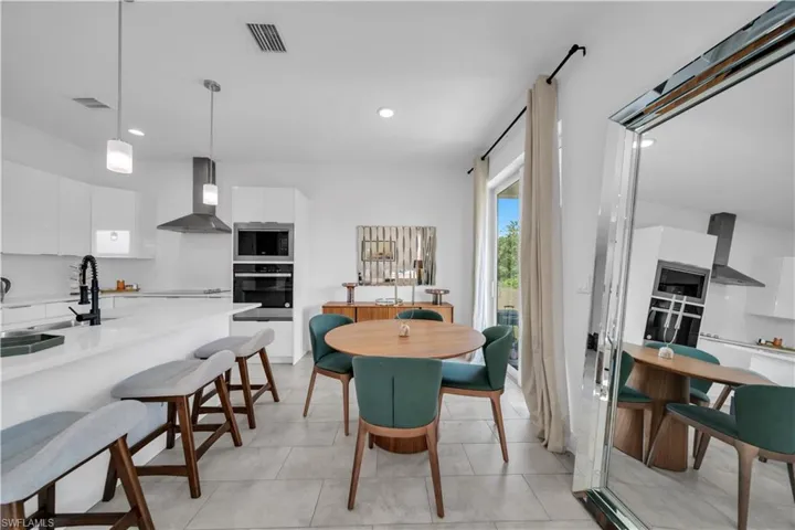 Bright kitchen featuring white cabinetry and light countertops