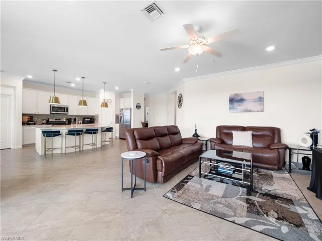 Living area featuring ornamental molding, recessed lighting, and ceiling fan