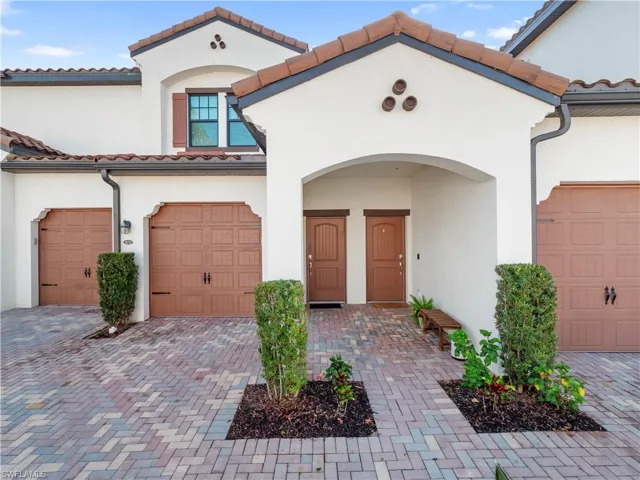 Mediterranean / spanish-style house featuring a tiled roof, a garage, stucco siding, and decorative driveway