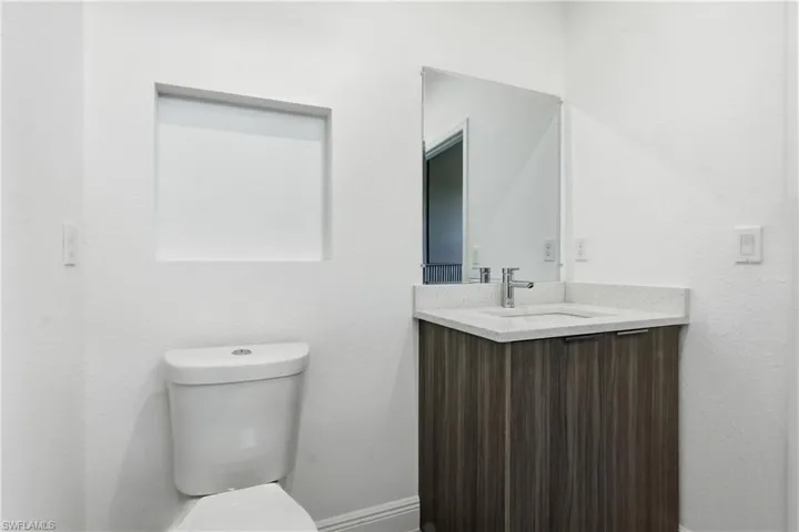 Full Bathroom featuring vanity and a textured wall