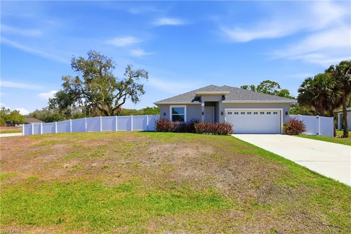 View of front of property with an attached garage, driveway, stucco siding, roof with shingles, and a gate