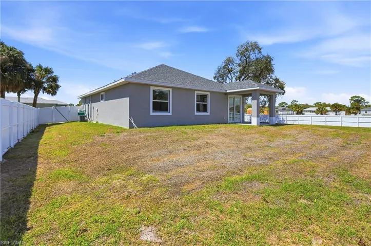 Rear view of property featuring a fenced backyard, stucco siding, a patio, and roof with shingles