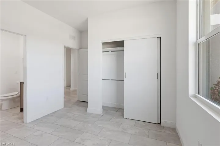 bedroom with a closet and ensuite bath