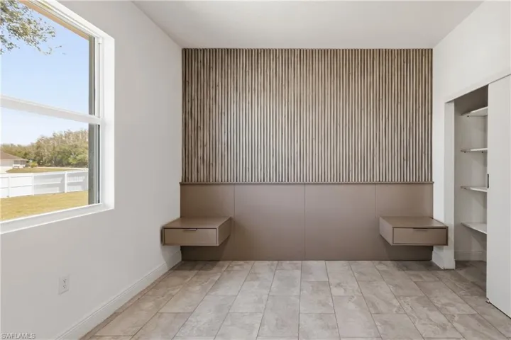 bedroom with an accent wall and baseboards