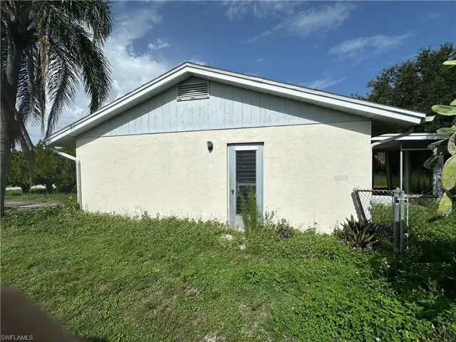 View of side of property with stucco siding and a lawn