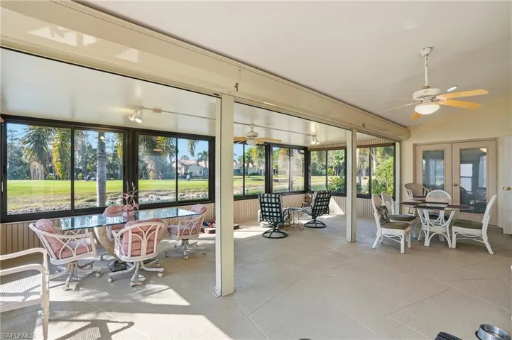 Sunroom featuring a ceiling fan, healthy amount of natural light, and vaulted ceiling