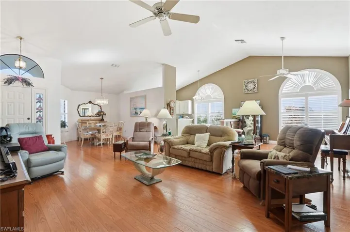 Living area featuring a chandelier, a ceiling fan, and light wood finished floors