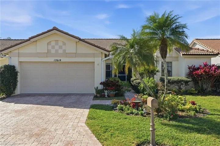 View of front of property featuring stucco siding, decorative driveway, and a tiled roof