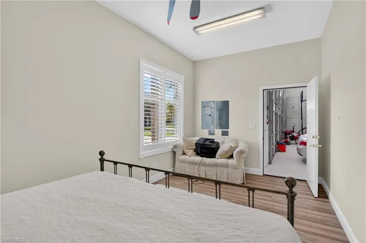 Hangar bedroom or office Bedroom featuring wood finished floors, electric panel, and a ceiling fan