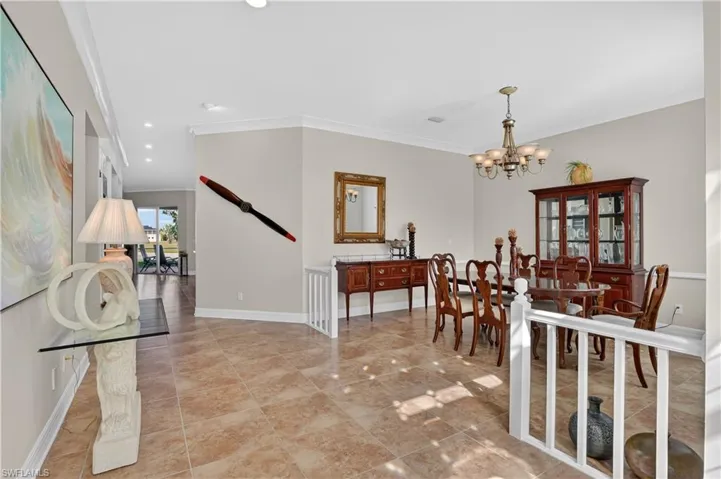 Dining area with crown molding, recessed lighting, a chandelier, and light tile patterned floors