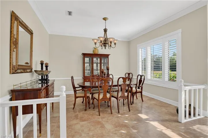 Dining space with ornamental molding and a chandelier