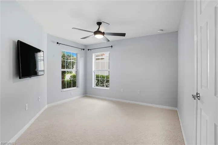Spare room featuring light colored carpet and ceiling fan
