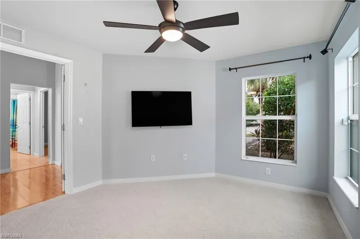 Unfurnished living room featuring light colored carpet and a ceiling fan
