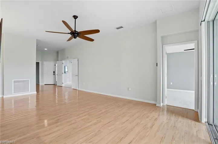 Unfurnished living room featuring light wood-style flooring and ceiling fan