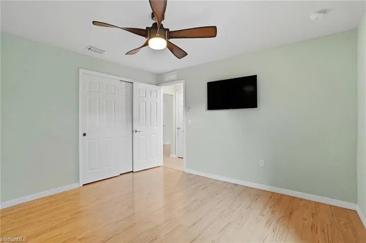 Unfurnished bedroom featuring a closet, ceiling fan, and light wood-type flooring