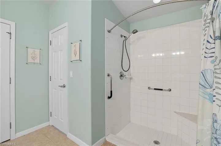 Bathroom featuring a shower stall and light tile patterned floors