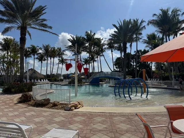 Community pool featuring a patio and a water play area