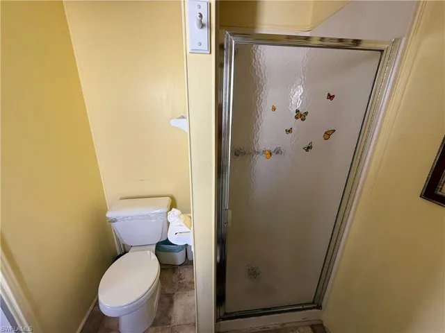 Bathroom featuring a shower stall and toilet